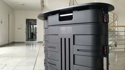 Ansicht der Vorderseite der Keffertheke Maxi mit schwarzer Tischplatte. (Koffertheke "Maxi")